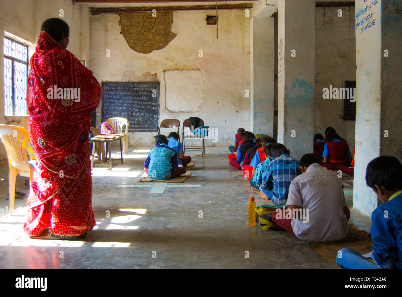 Les enfants de l'Inde rurale assise sur le sol et l'étude. Banque D'Images