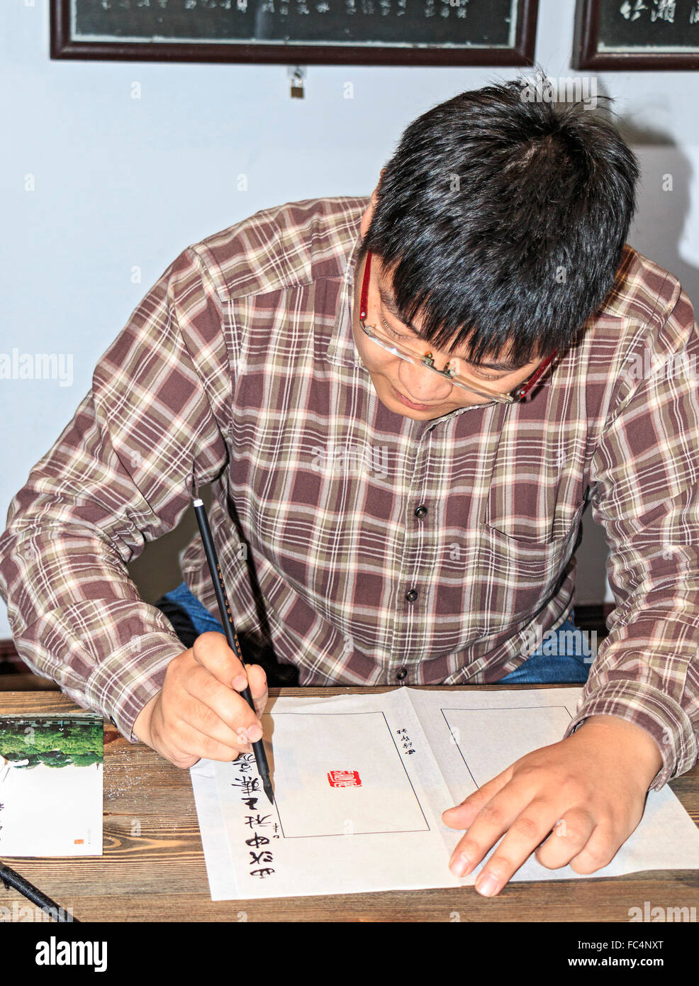 Wang Zhen, un maître graveur, enseigne aux élèves comment découper un joint ou joint de Xiling à hacher la société du graveur à Hangzhou, Chine. Banque D'Images