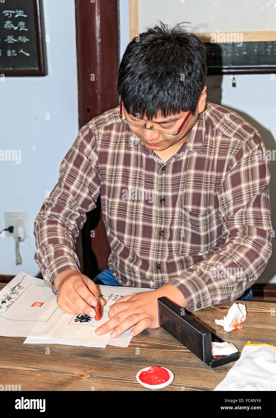 Wang Zhen, un maître graveur, enseigne aux élèves comment découper un joint ou joint de Xiling à hacher la société du graveur à Hangzhou, Chine. Banque D'Images
