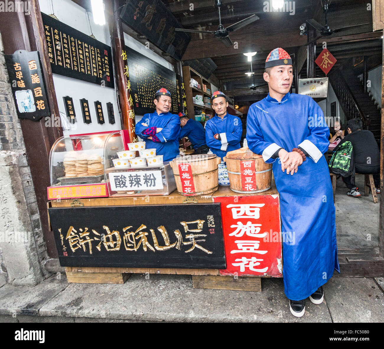 Les hommes en robe de style ancien en vente de produits alimentaires le long de la rue Qinghefang boutique ancienne à Hangzhou, Chine Banque D'Images