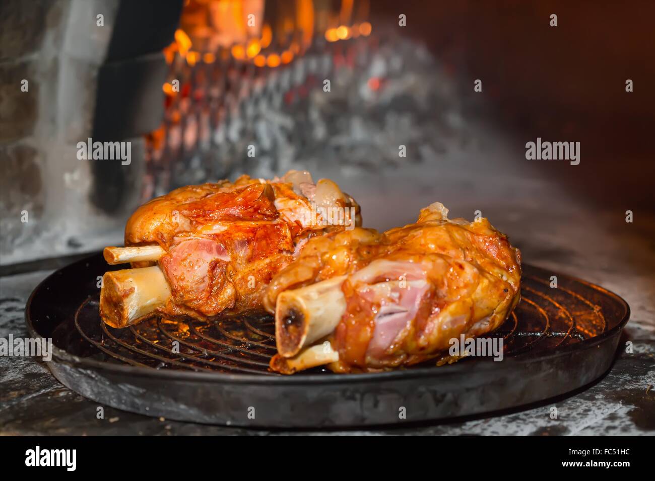 Jarret de porc rôti au four dans un four en brique Banque D'Images