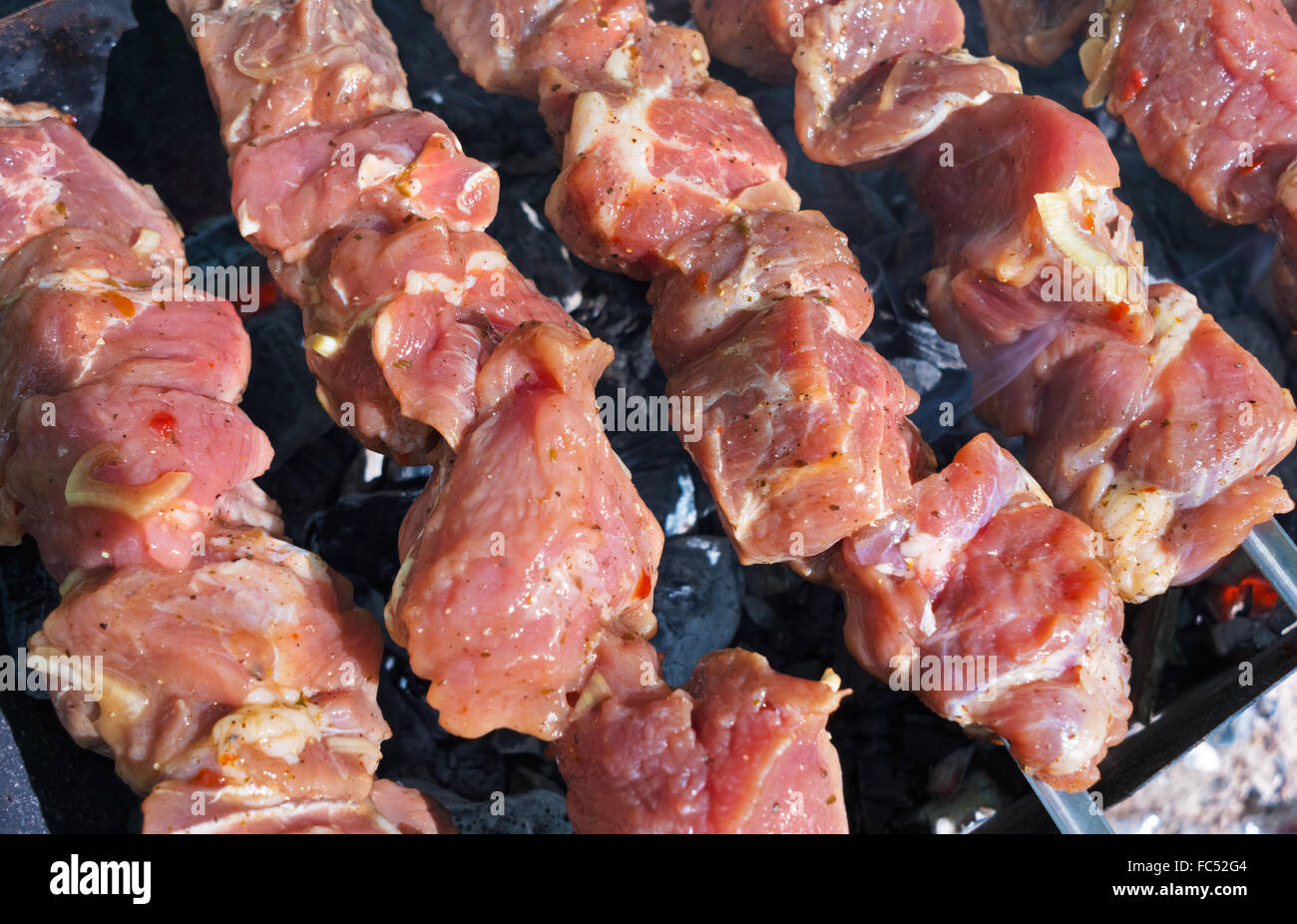 La cuisson de la viande marinée sur un grill Banque D'Images