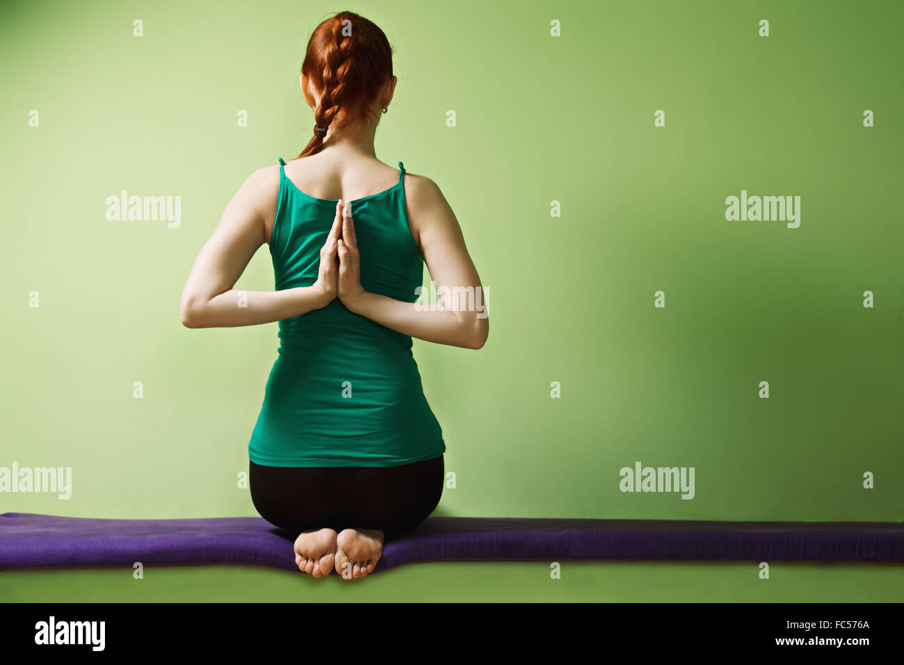 Yoga woman folding palms behind back Banque D'Images