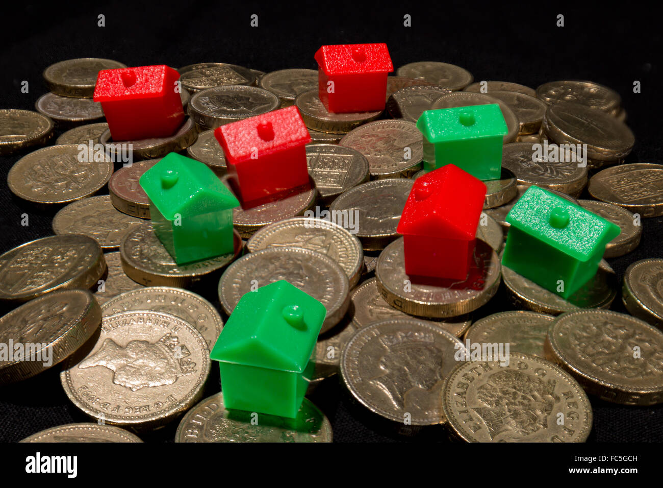 Les maisons rouge et verte sur un tas de pièces Livre britannique Banque D'Images