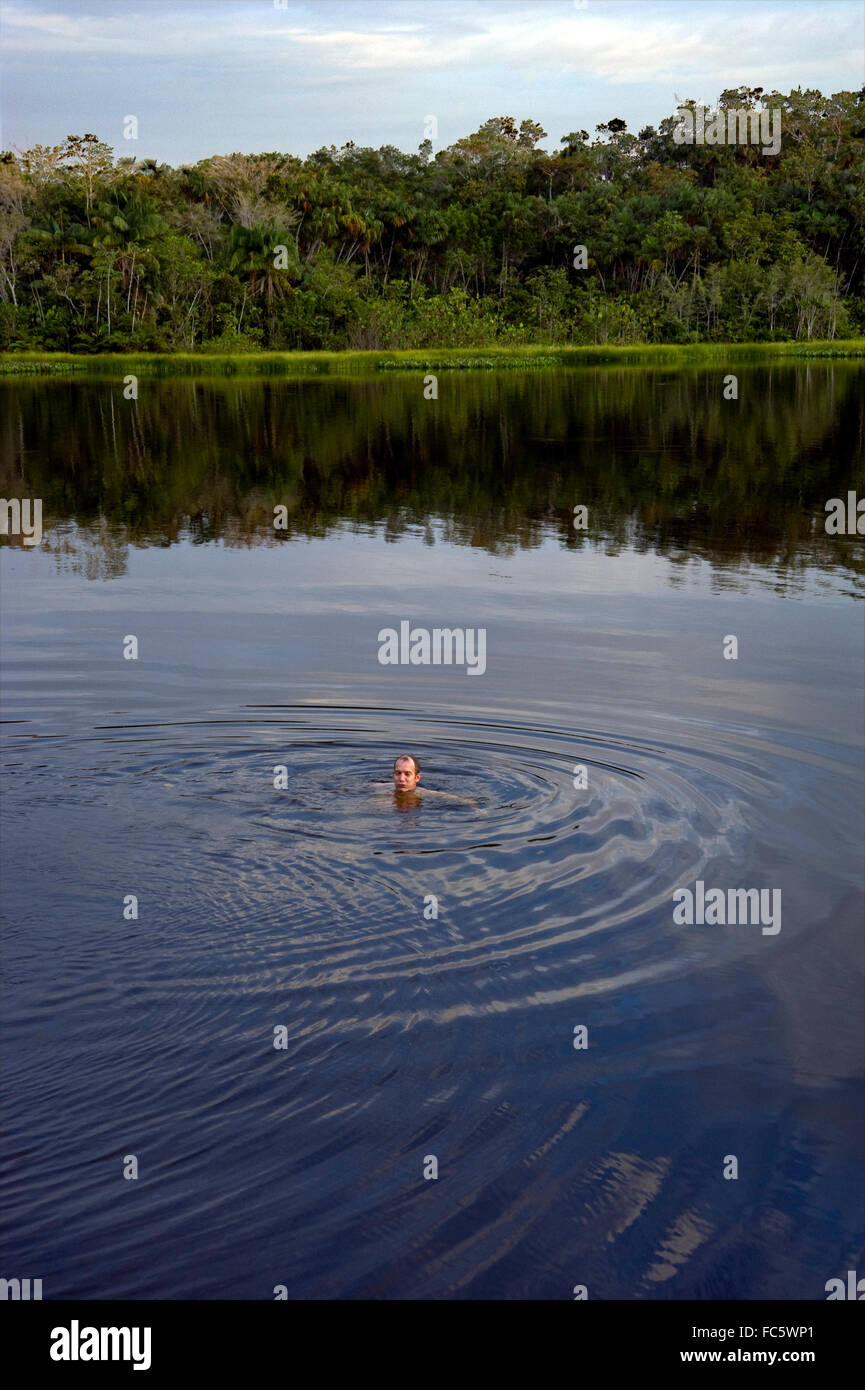 L'homme nage dans le fleuve Amazone en Equateur Banque D'Images