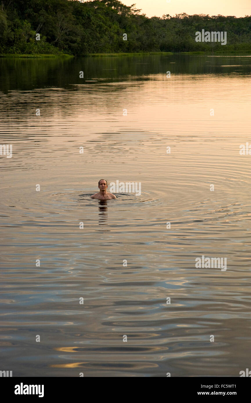 L'homme nage dans le fleuve Amazone en Equateur Banque D'Images