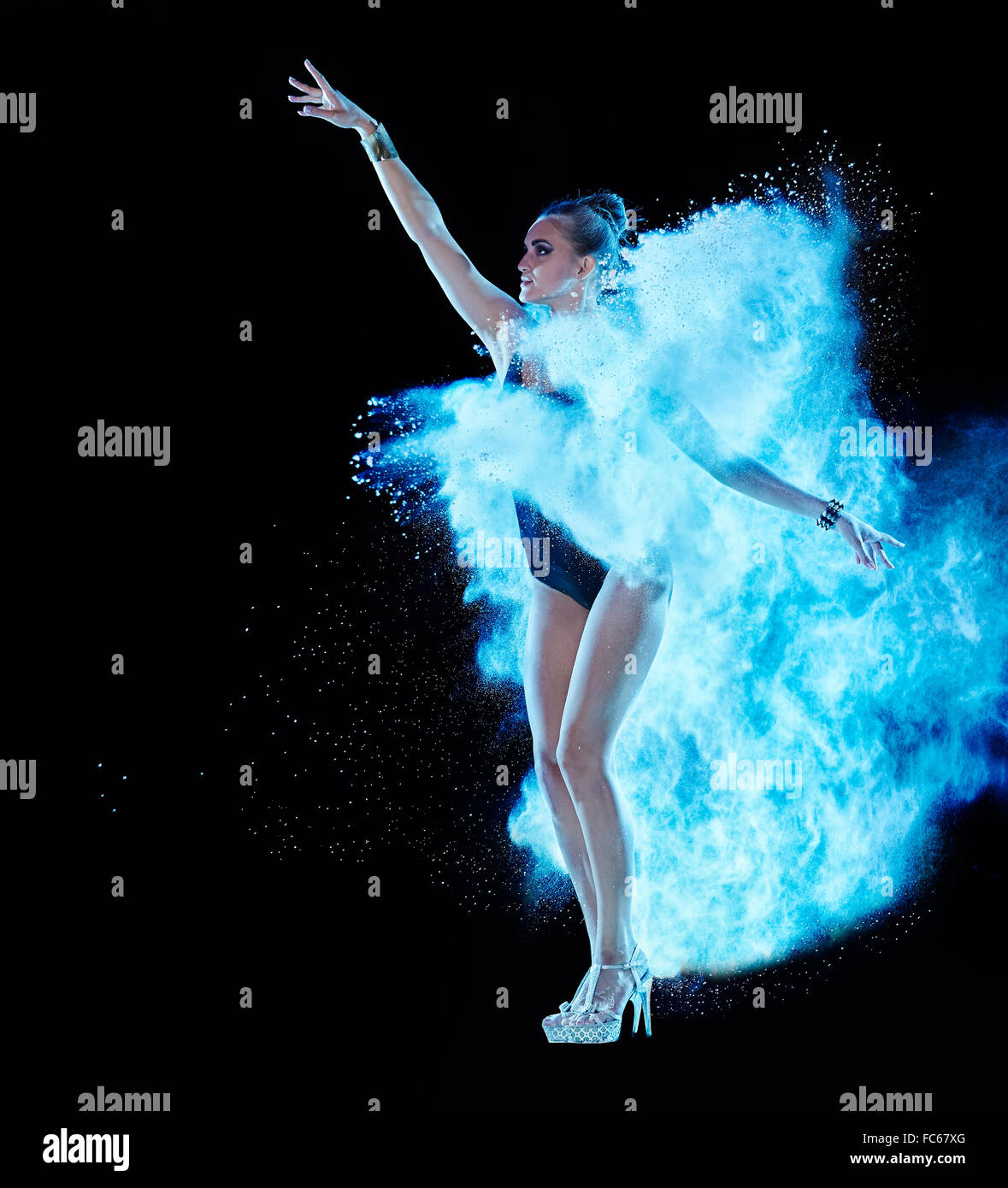 Jeune femme sautant en bleu nuage de poudre Banque D'Images
