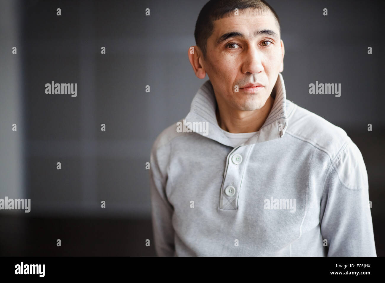 Close up portrait of man brune dans les tenues avec les cheveux courts de façon réfléchie à la recherche directement dans l'appareil photo, l'employé reçoit, habillé d'pull léger. Copie de l'espace pour votre texte. Banque D'Images