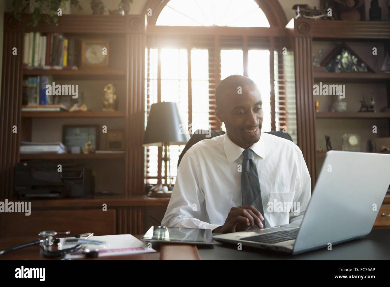 Black doctor using laptop in office Banque D'Images Black doctor using laptop in office Banque D'Images