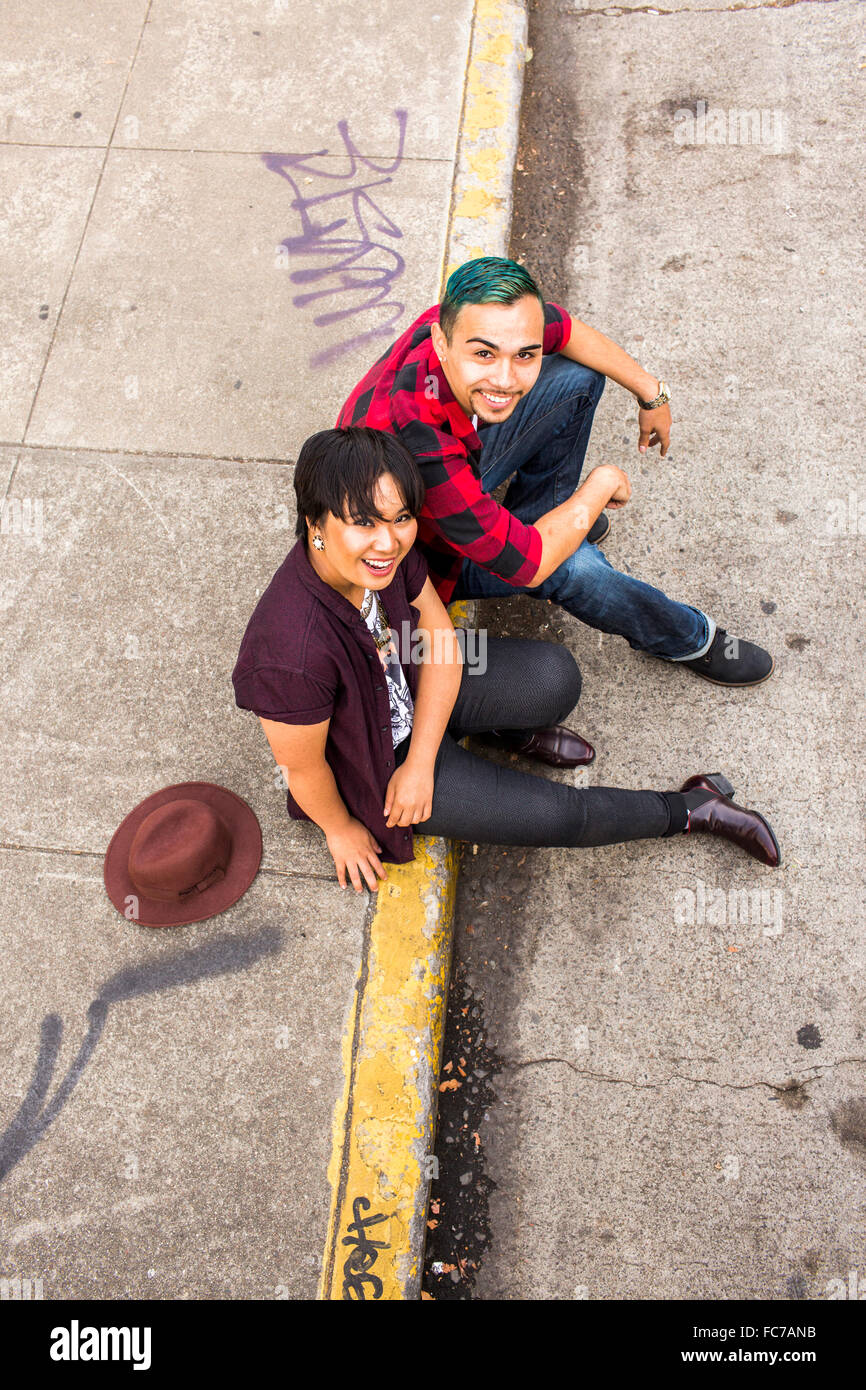 High angle view of couple sitting on curb Banque D'Images