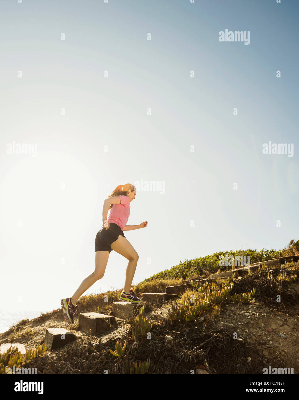 Caucasian woman jogging uphill Banque D'Images
