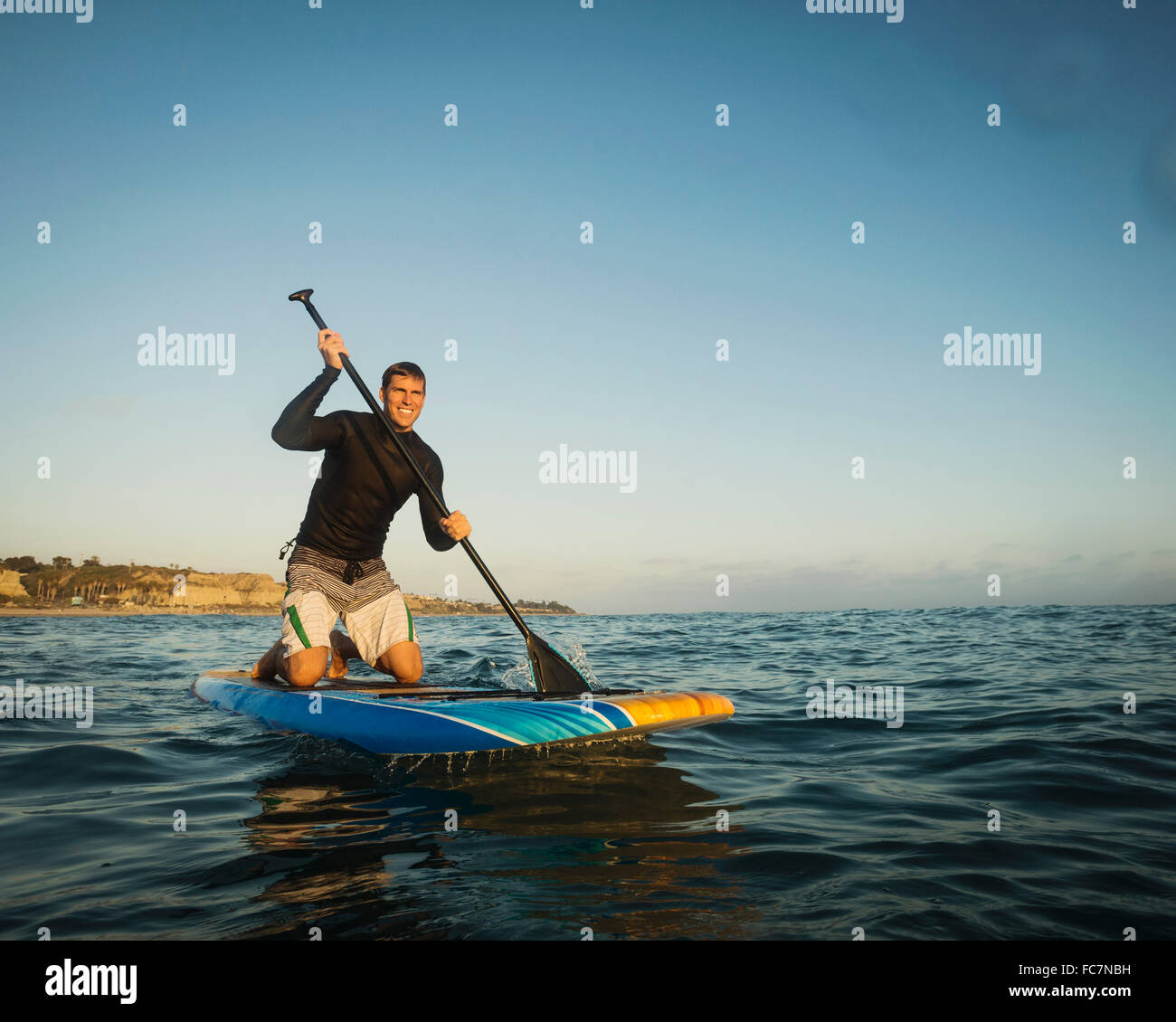 Caucasian man on paddle board in ocean Banque D'Images