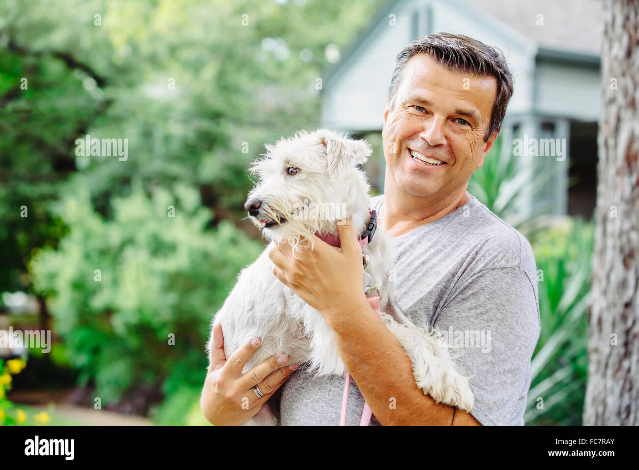 Caucasian man petting dog outdoors Banque D'Images
