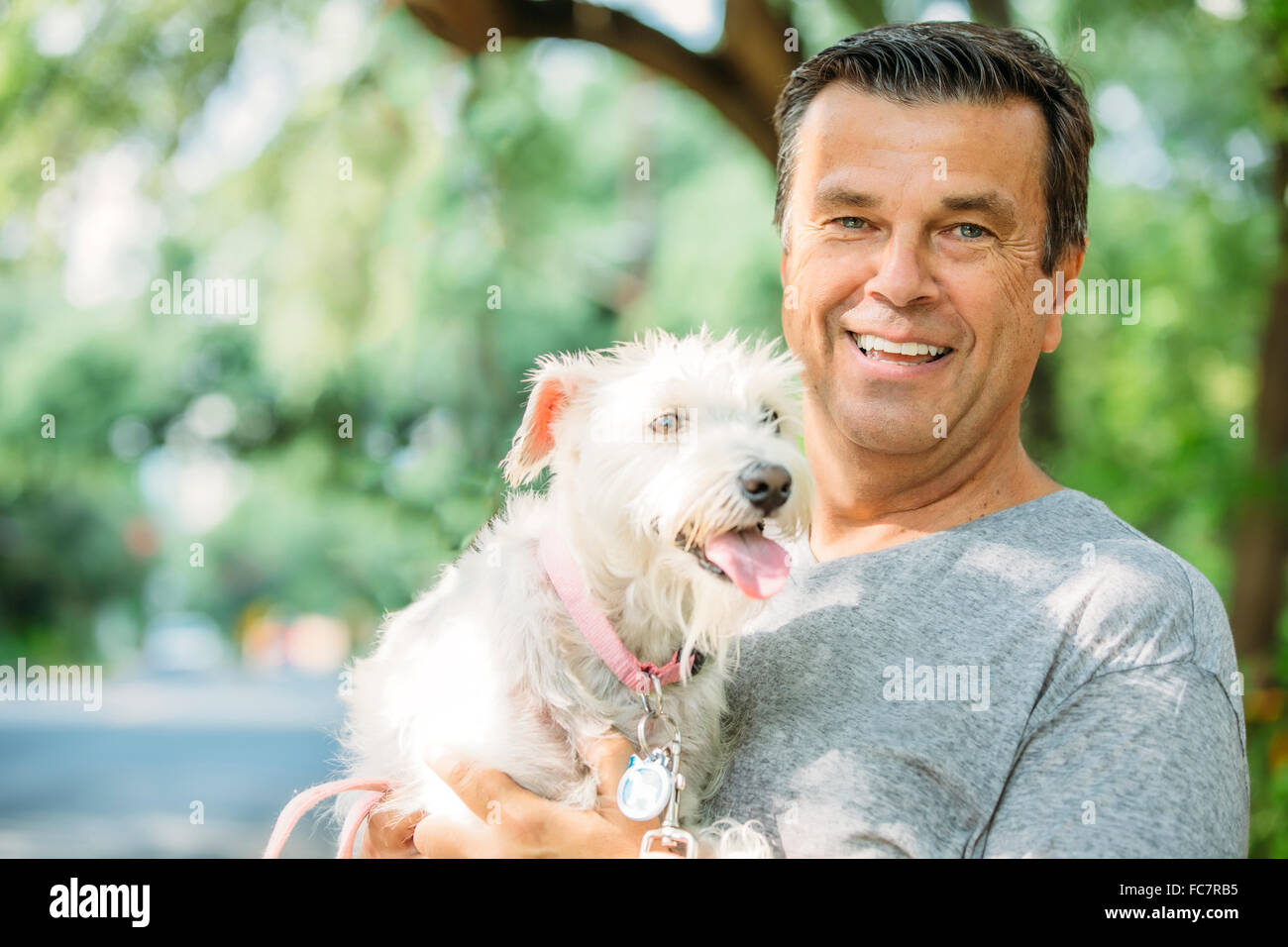 Caucasian man petting dog outdoors Banque D'Images