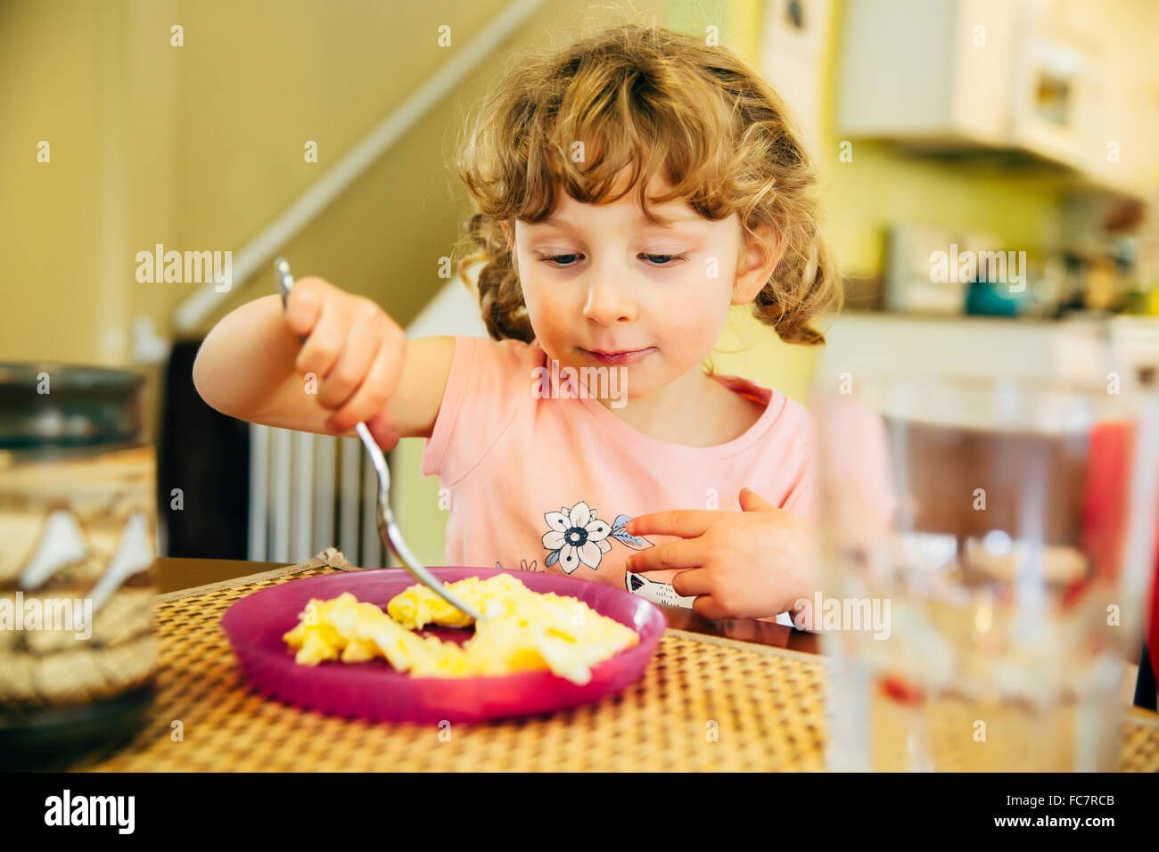 Caucasian girl eating at table Banque D'Images