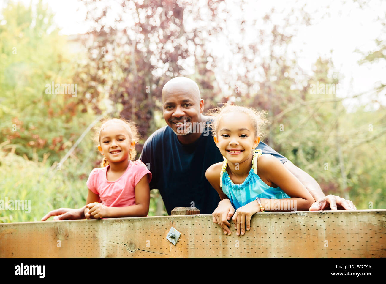 Père et filles smiling outdoors Banque D'Images