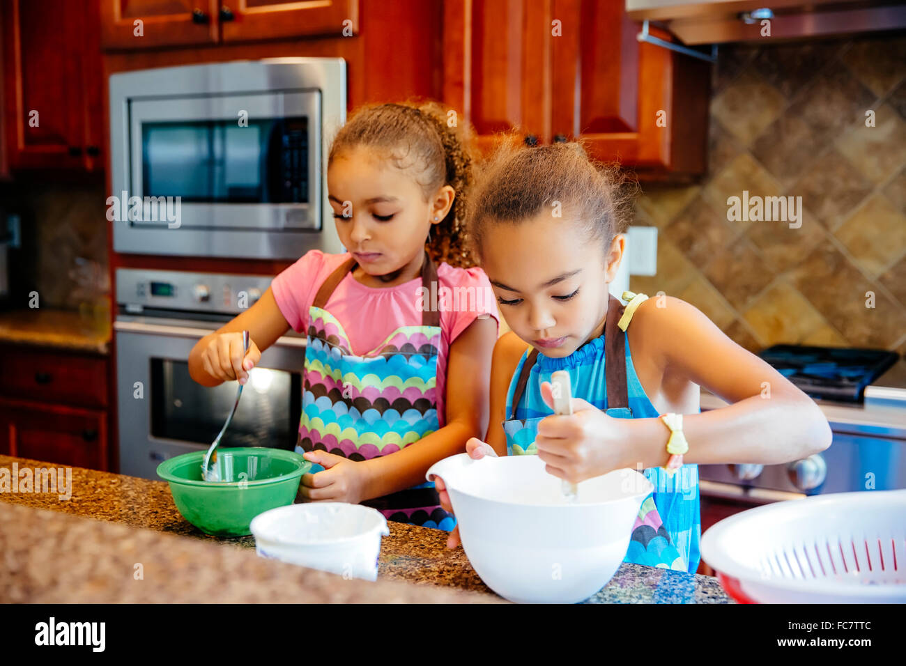 Mixed Race girl cooking in kitchen Banque D'Images