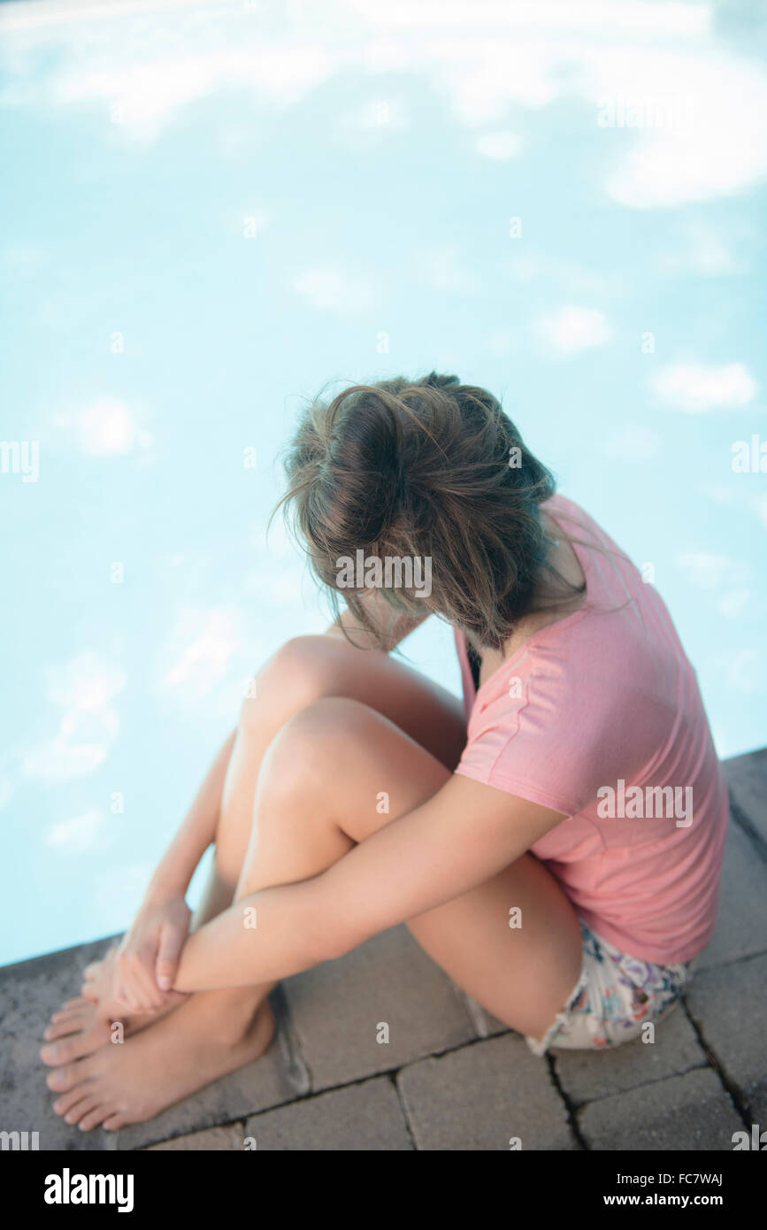 Caucasian woman sitting at swimming pool Banque D'Images