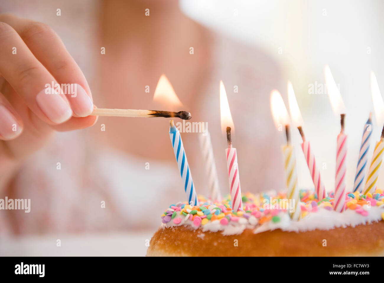 L'éclairage des bougies d'anniversaire femme hispanique Banque D'Images