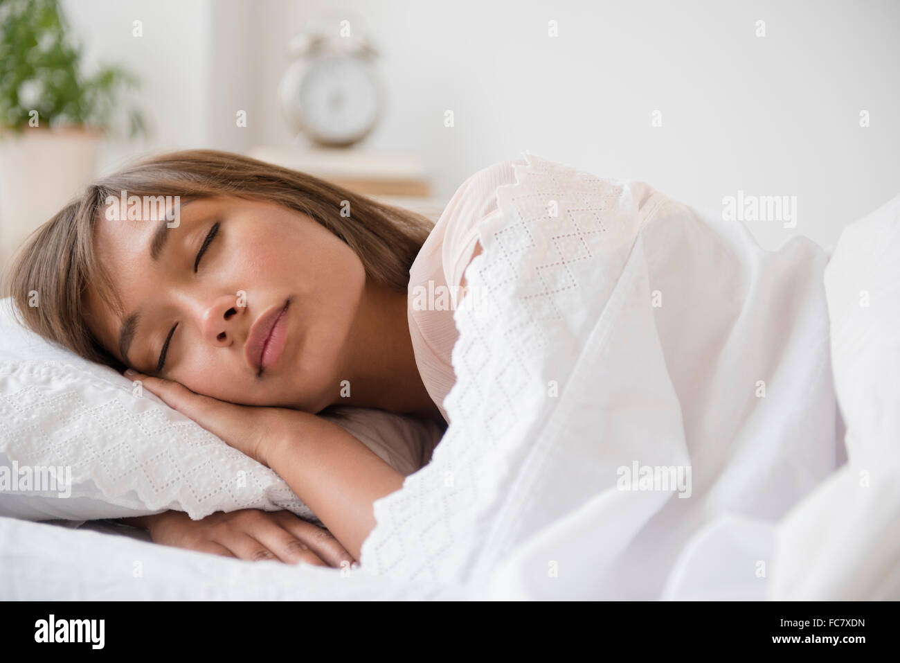 Mixed Race woman sleeping in bed Banque D'Images