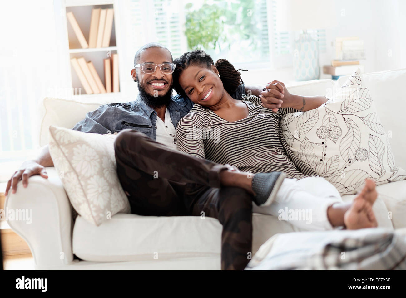 Black couple smiling on sofa Banque D'Images