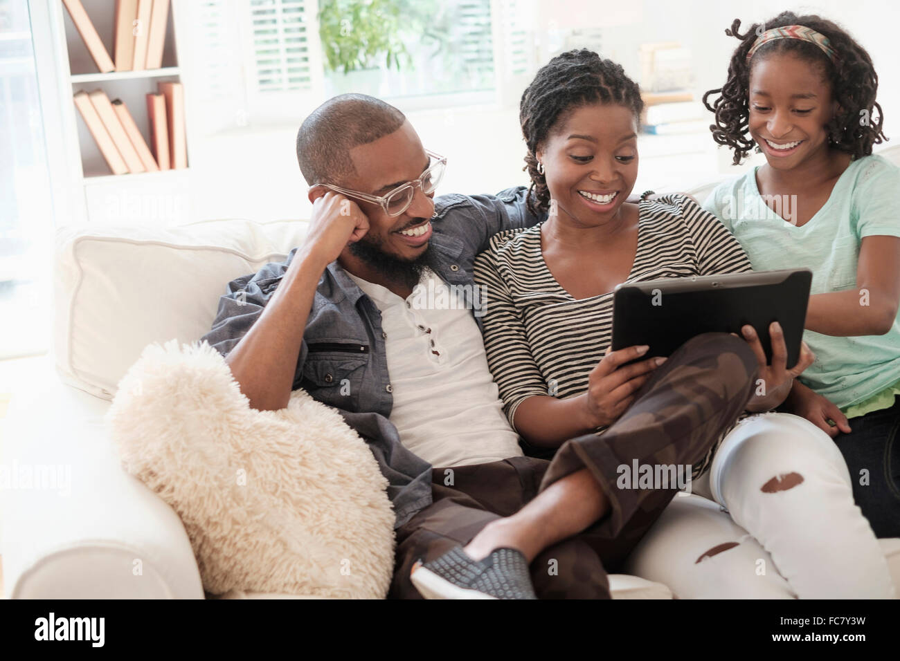 Black family sitting on sofa Banque D'Images