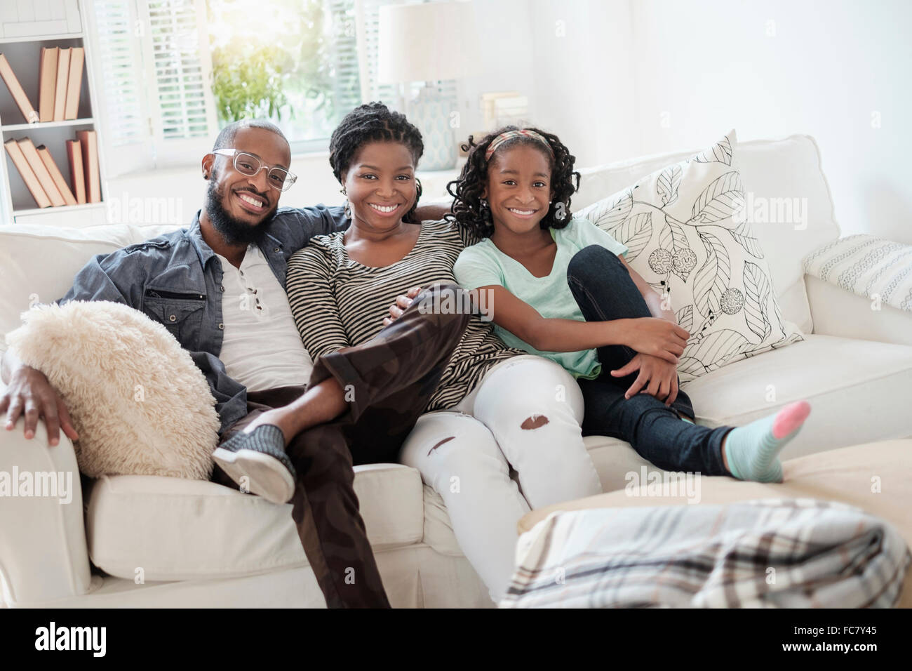 Black family smiling on sofa Banque D'Images