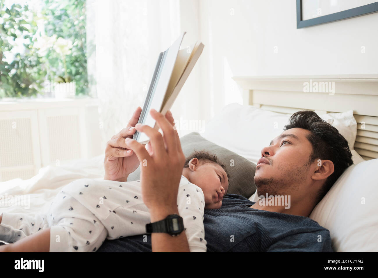 Avec lecture père fils bébé endormi Banque D'Images