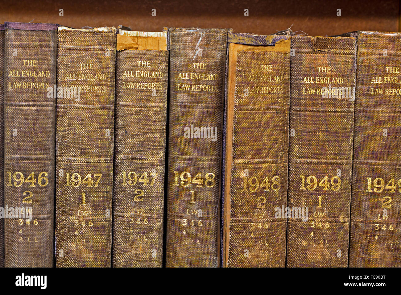 Gros plan de vieux volumes usés des All England Law Reports de 1946 à 1949 avec des lettres dorées sur une étagère en bois. Banque D'Images