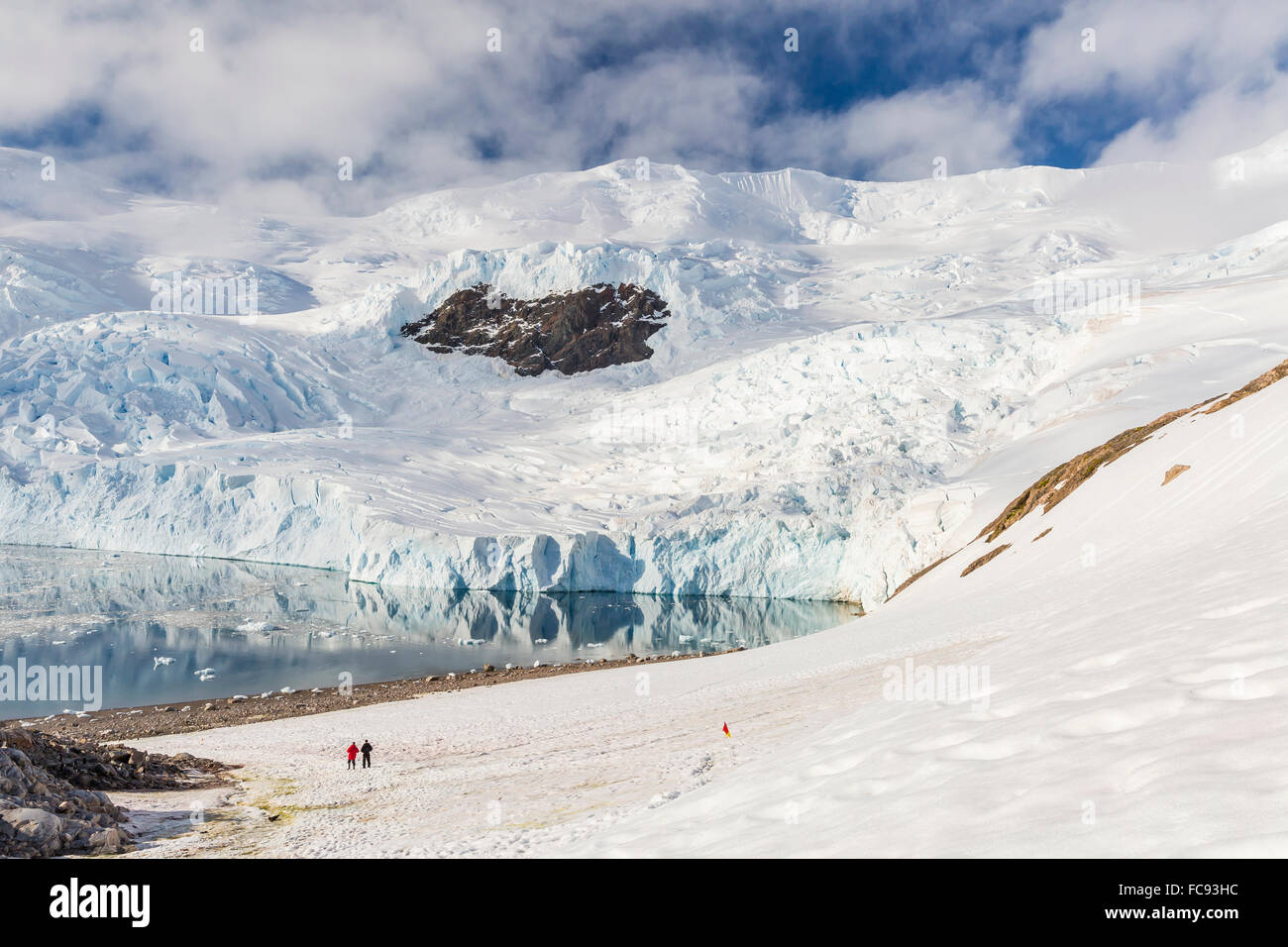 Deux randonneurs entouré de montagnes couvertes de glace et les glaciers en Neko Harbour, l'Antarctique, régions polaires Banque D'Images