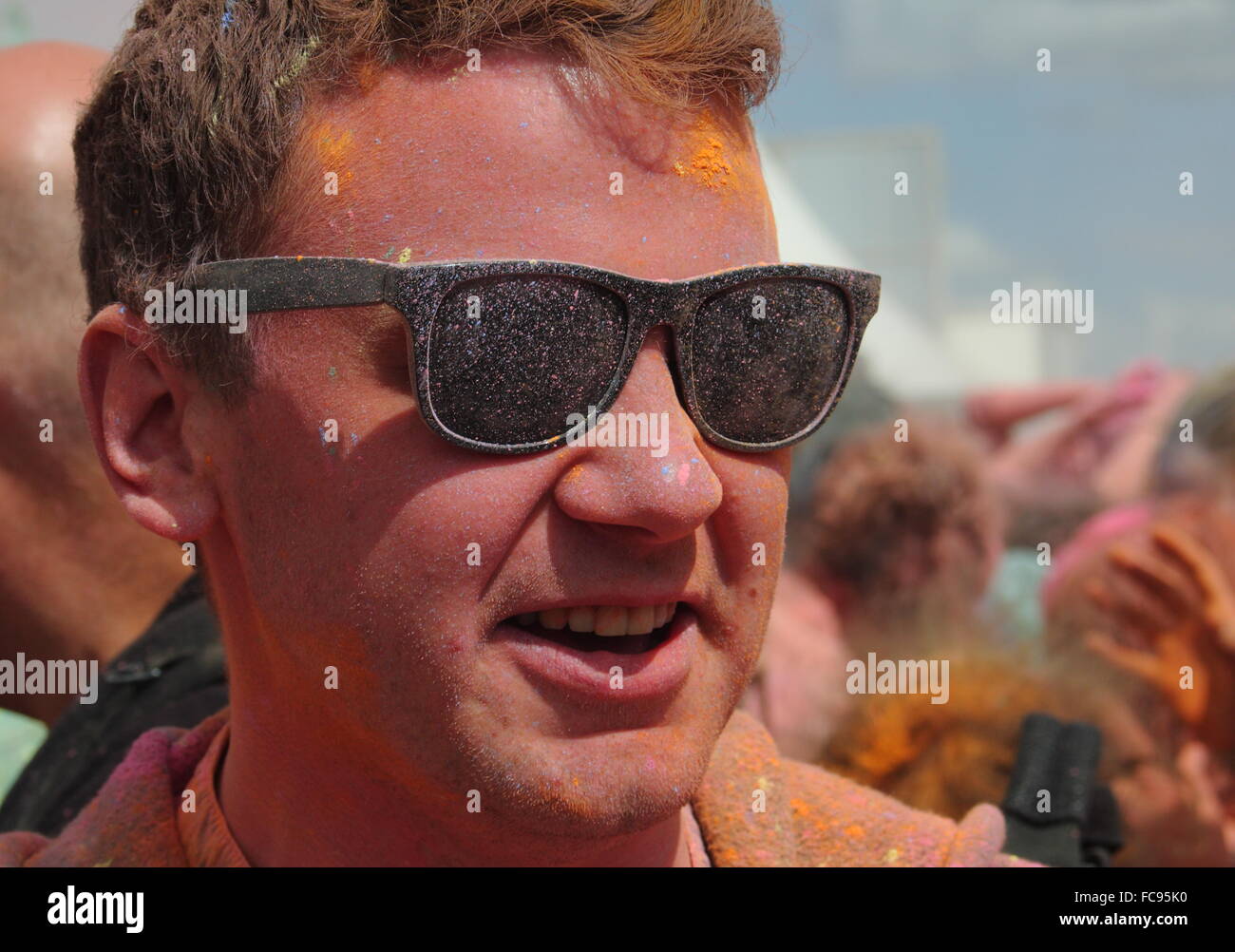 Un festival goer a une face orange après avoir pris part à un événement de lancement de peinture en poudre à l'Y PAS music festival, Derbyshire, Royaume-Uni Banque D'Images