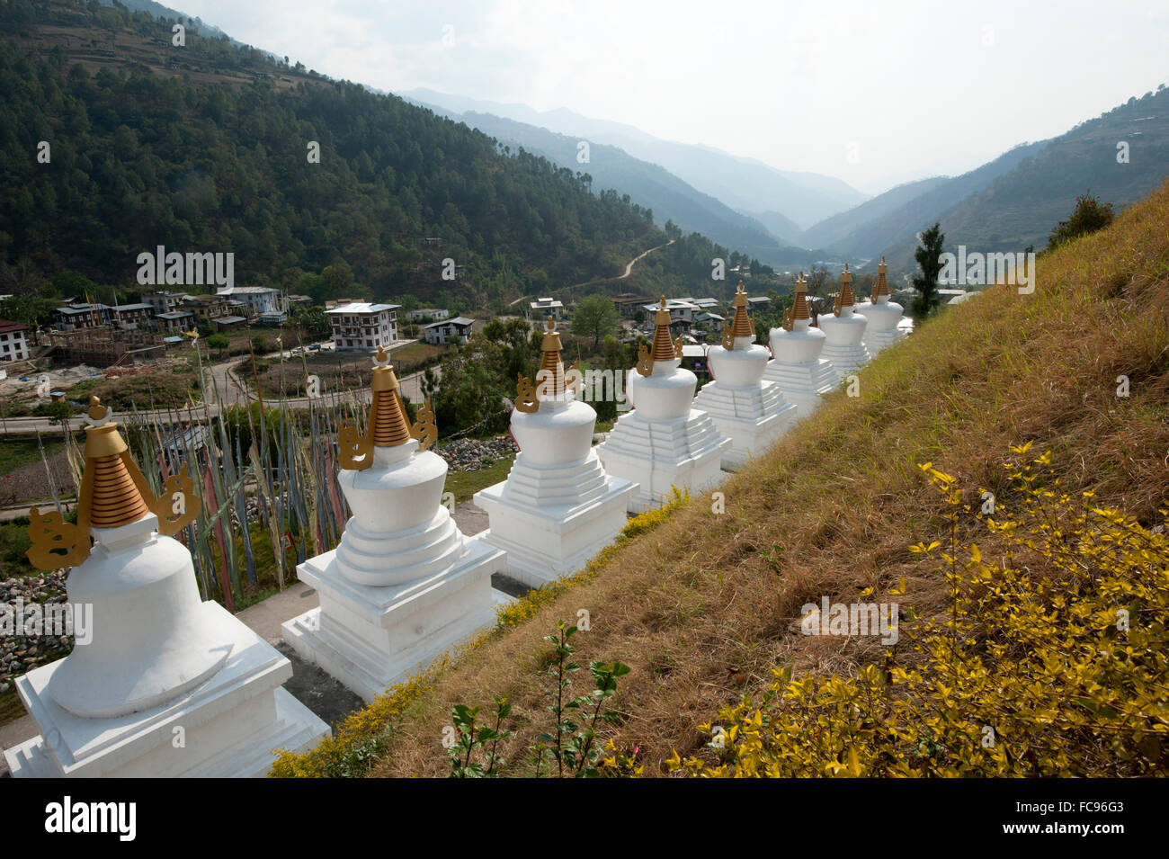 Rangée de chortens blancs à l'entrée de Rangjung monastère bouddhiste dans les belles collines au-dessus de l'Est du Bhoutan, Trashigang Banque D'Images