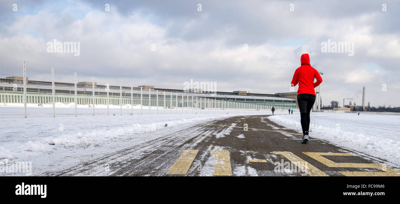 Une femme en jogging avant de la de l'ancien des hangars de l'Aéroport de Tempelhof à Berlin, Germanym, 20 janvier 2016. Le sénat's plans controversés pour l'hébergement des réfugiés sur Tempelhofer Feld seront examinés à une rencontre de citoyens. PHOTO : THOMAS MOLL/DPA Banque D'Images