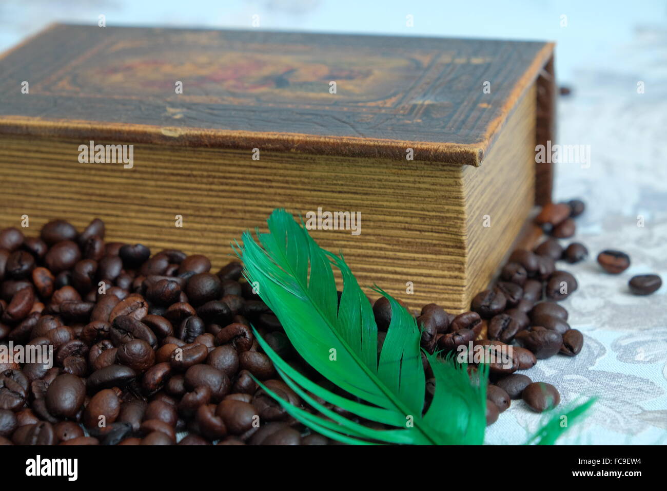 Les grains de café torréfié, de vieux livre et un stylo vert Banque D'Images