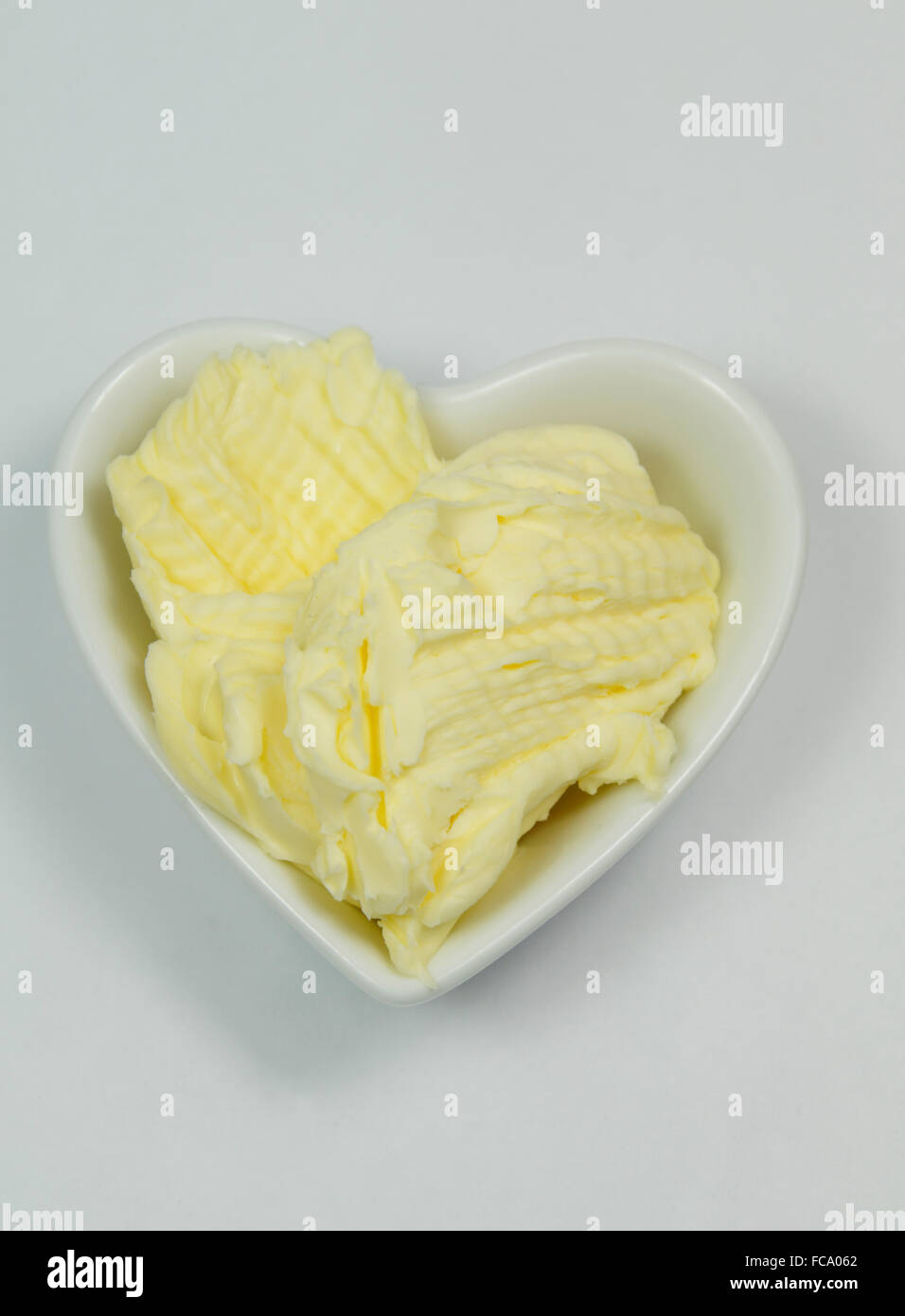Le beurre dans un plat en forme de coeur. Banque D'Images