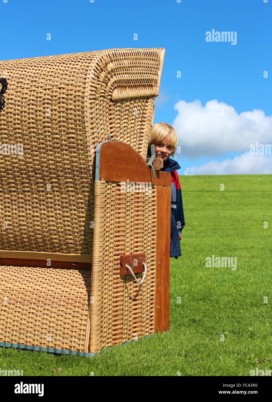 Garçon dans une chaise de plage à la digue Banque D'Images