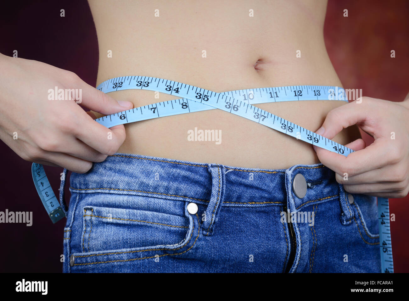 Femme asiatique slim , portant des jeans, la mesure de sa forme du corps, de la taille, des fesses Banque D'Images