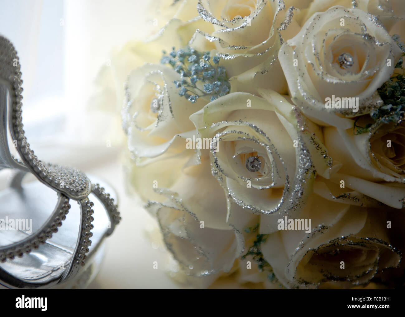 Chaussures de la mariée et bouquet sur un fond blanc. Banque D'Images