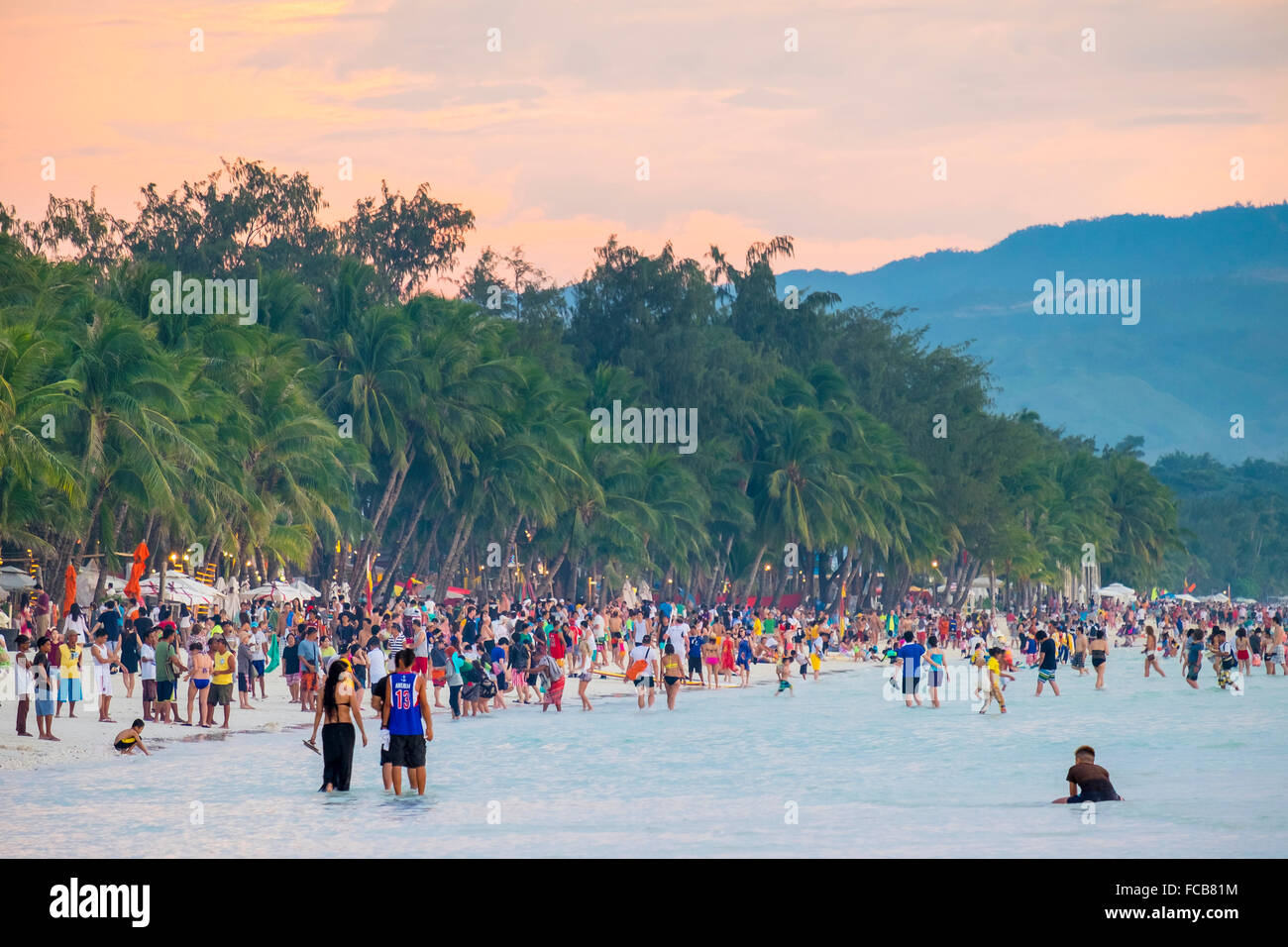Des foules de gens sur la plage blanche au coucher du soleil, Boracay, Philippines Banque D'Images