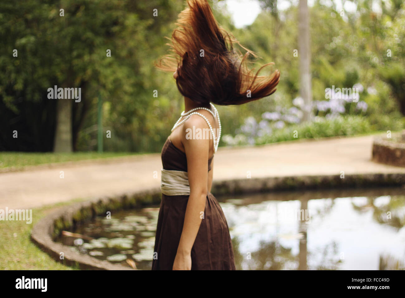 Vue latérale d'une femme avec les cheveux bruns soufflé par Campagne Lac Banque D'Images