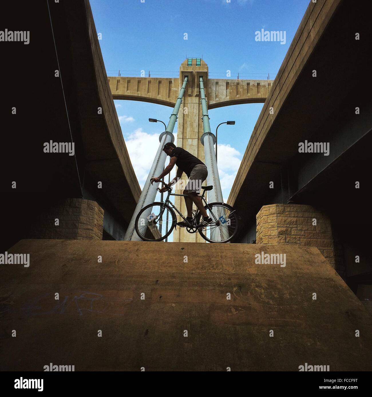 Low Angle View Of Man en équilibre sur vélo le long Bridge Banque D'Images