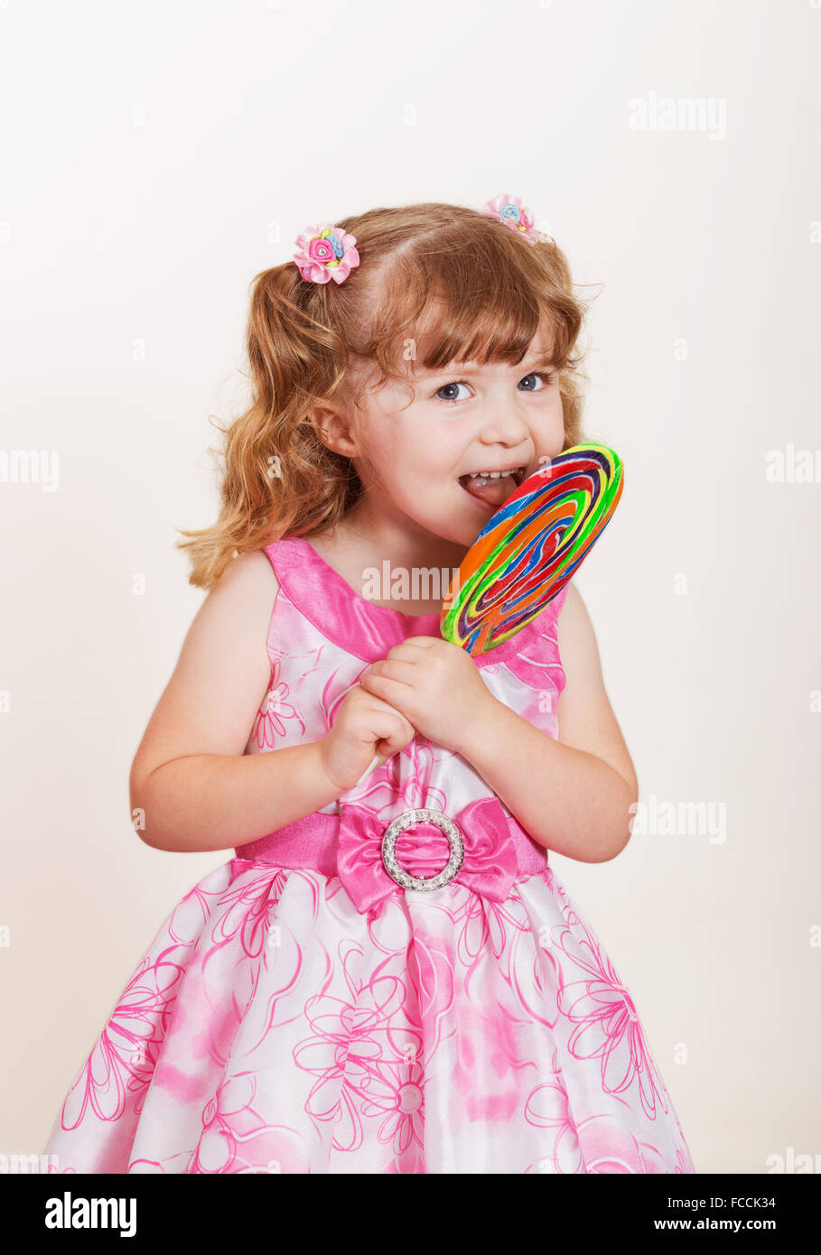 Portrait of cute little Girl with big lollipop colorés sur un fond clair Banque D'Images