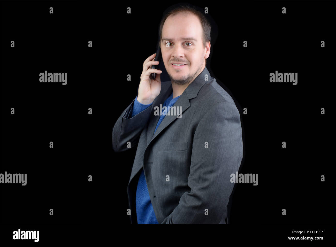 Jeune homme costume gris foncé parler mobile phone smiling Banque D'Images
