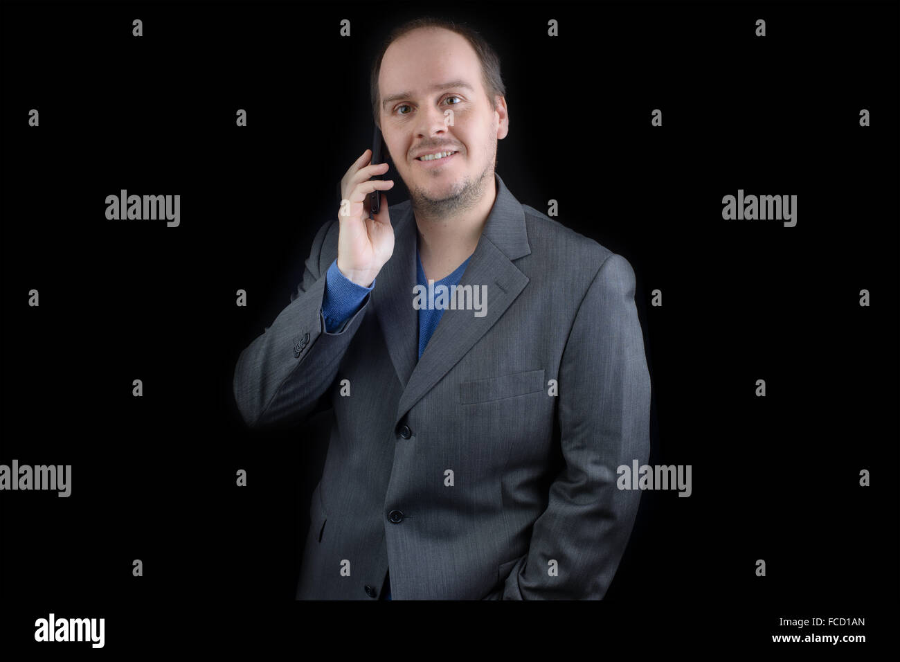 Jeune homme veste de costume gris foncé parler mobile phone smiling Banque D'Images