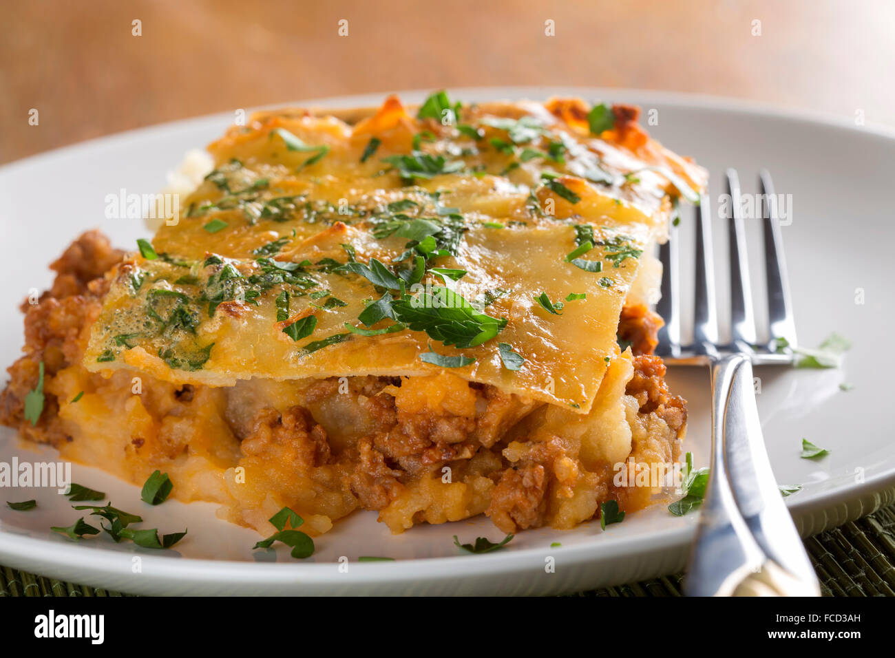 La Moussaka avec de la viande hachée, les pommes de terre et le persil on white plate Banque D'Images