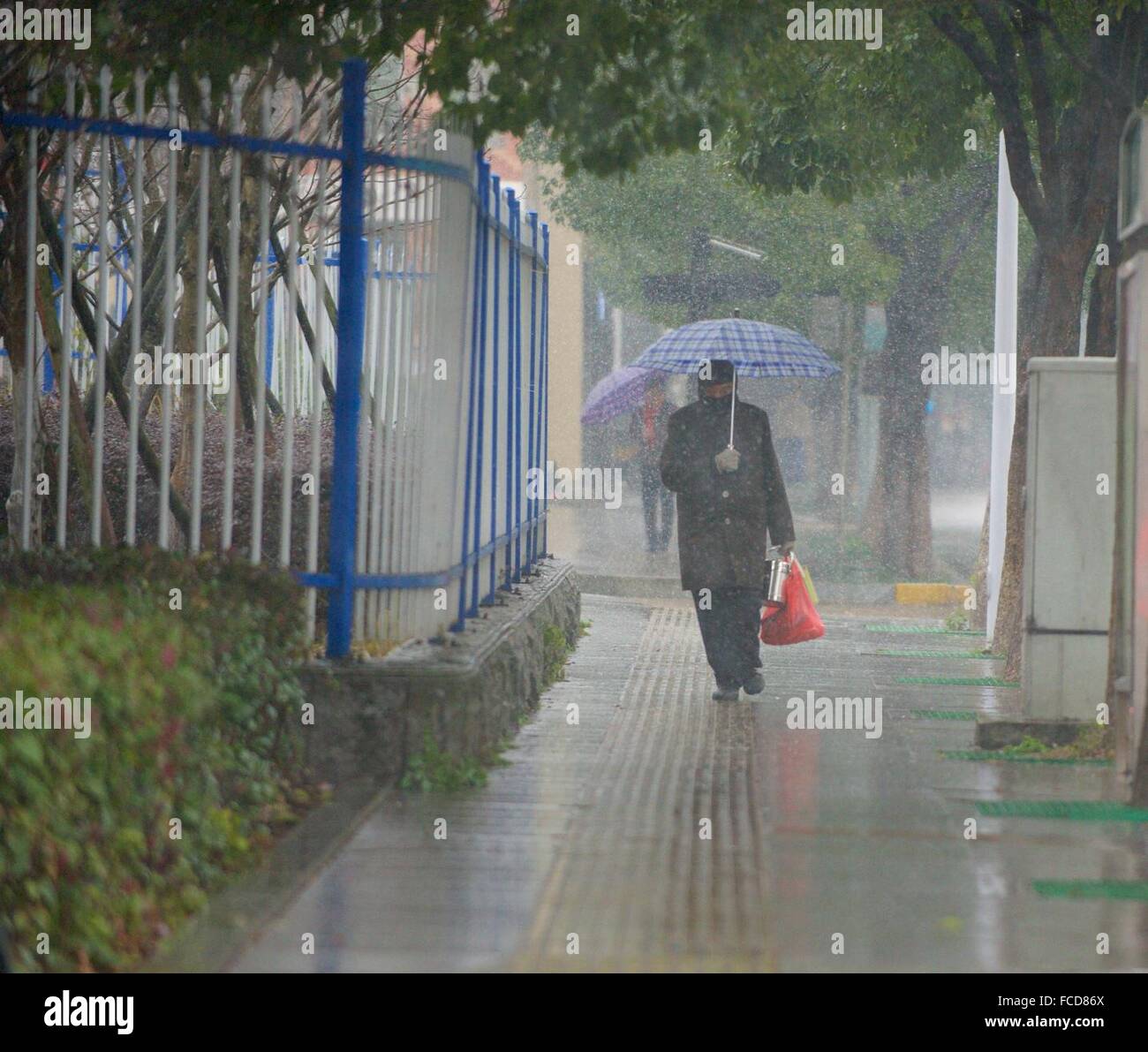 Jiujiang, Chine, province de Jiangxi. 22 janvier, 2016. Les gens marchent dans une rue de la ville de Jiujiang, province de Jiangxi en Chine orientale, le 22 janvier 2016. Une grande partie de Jiangxi a été frappé par les tempêtes de neige vendredi. C'est le temps le plus froid depuis 1992 est prévu de Janvier 23 à 26. Credit : Hu Chenhuan/Xinhua/Alamy Live News Banque D'Images