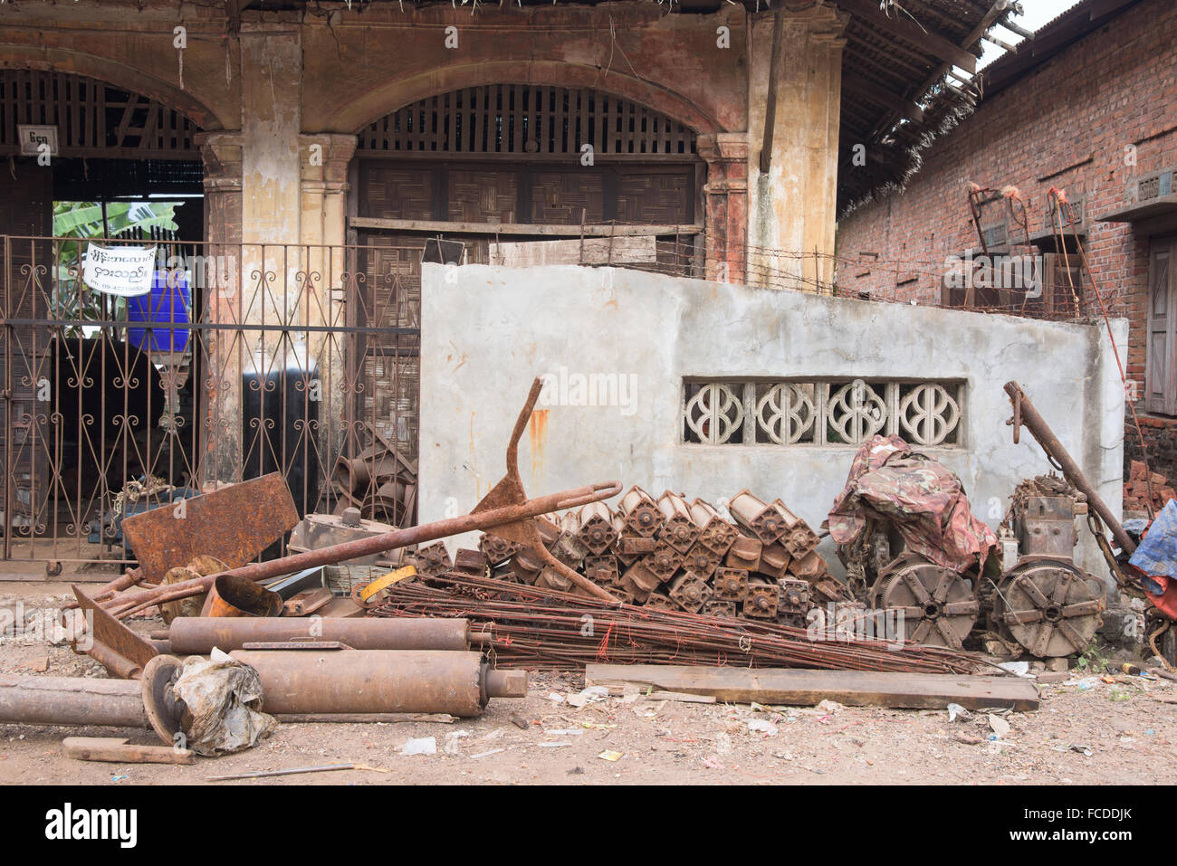 Pièces de la machine rouillée dans la rue devant un atelier local à Myeik, Myanmar. Banque D'Images