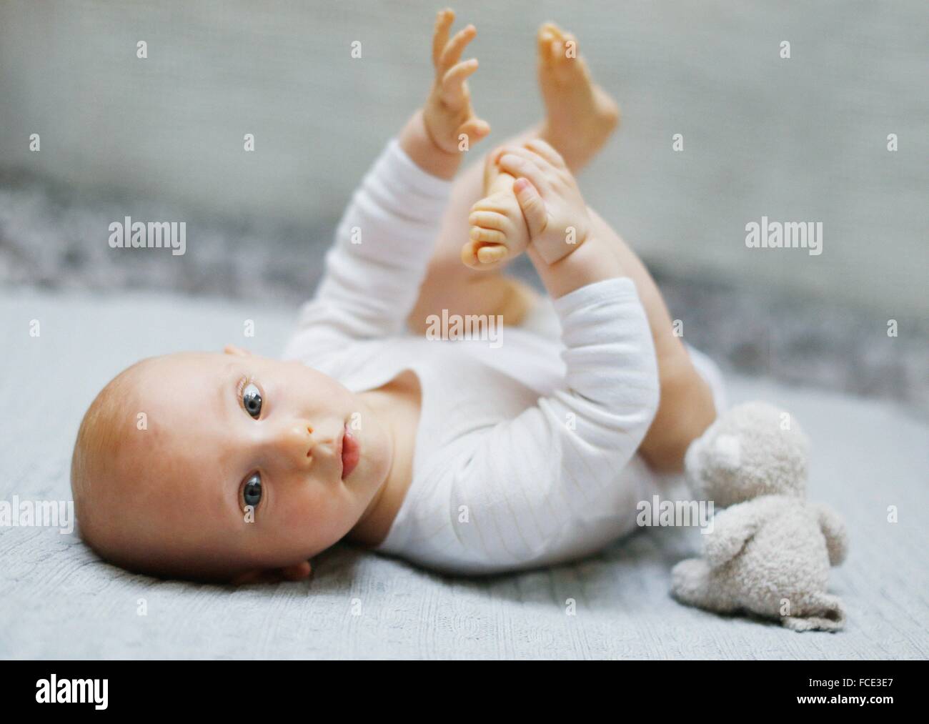8 mois bébé garçon couché et jouant avec ses pieds Photo Stock - Alamy