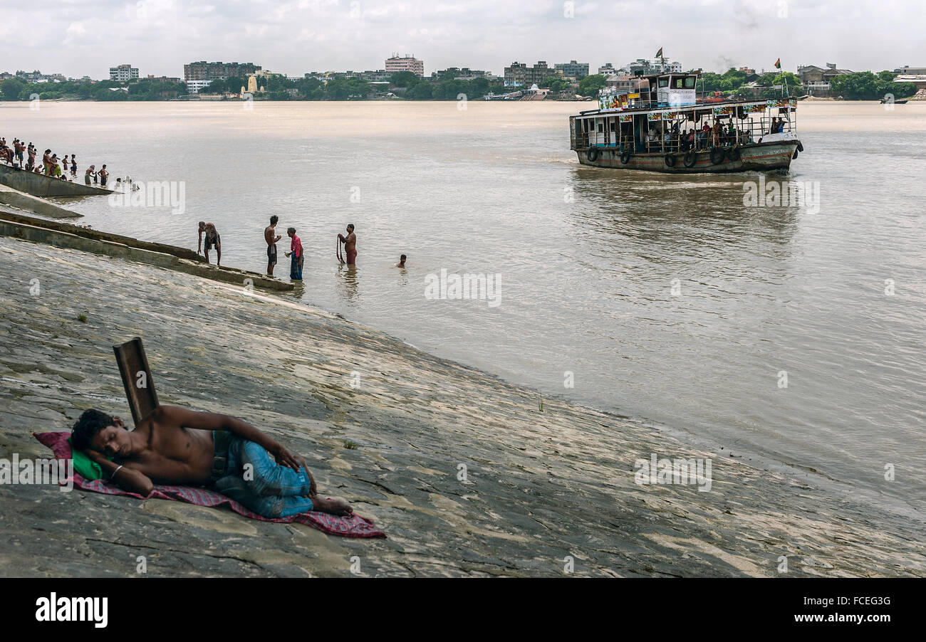 Un sans-abri, des gens endormis, baignade et d'un ferry public comme il traverse l'Hooghly à Howrah. Banque D'Images