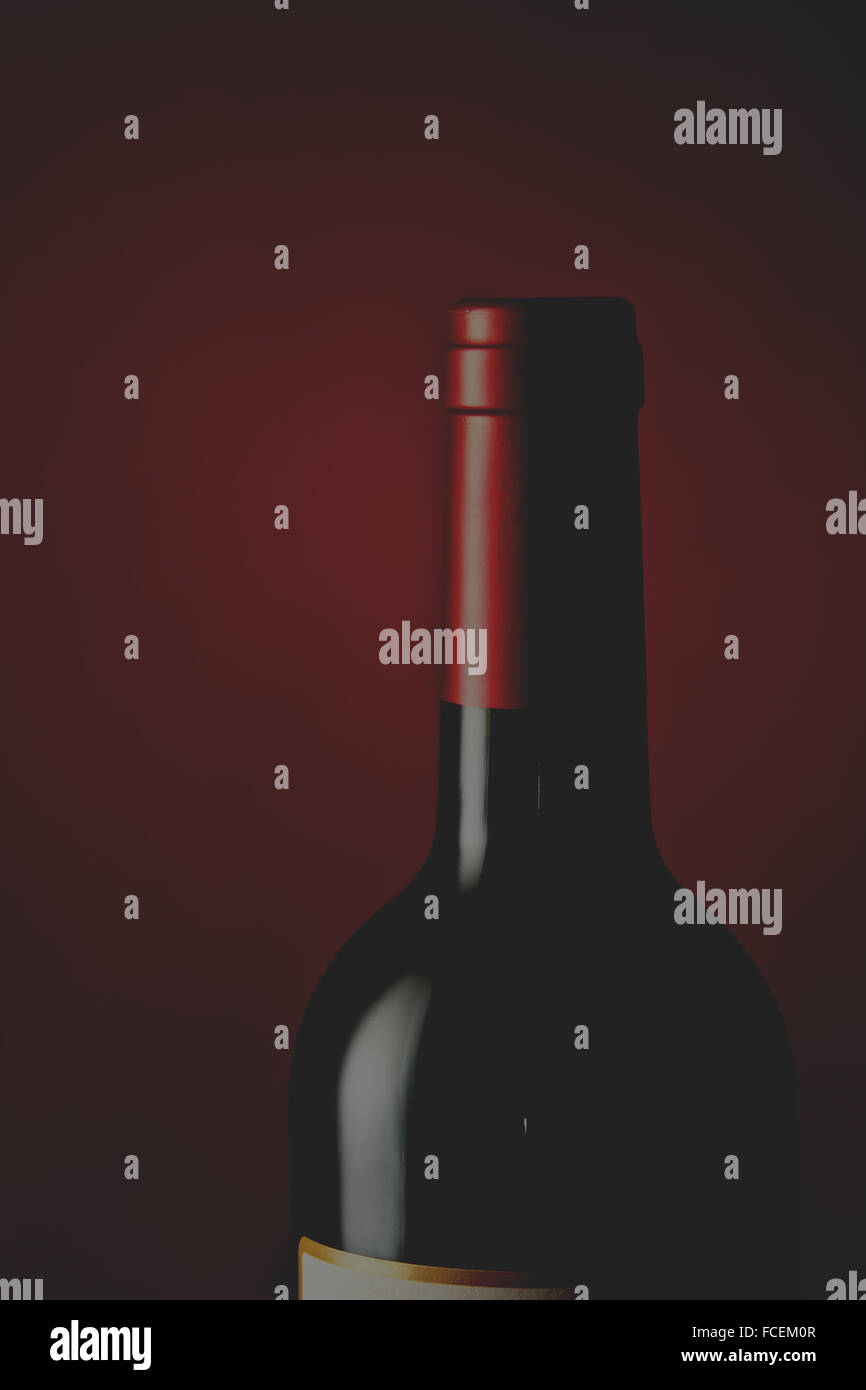 Une seule bouteille de vin de Bordeaux en français sur une base de Crimson et toile de fond. Banque D'Images
